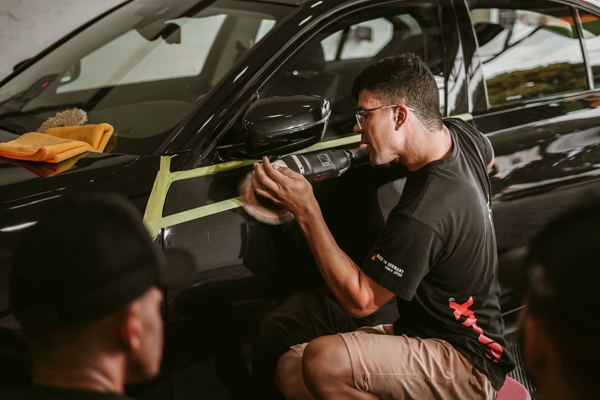 Profissional realizando polimento técnico em um automóvel
